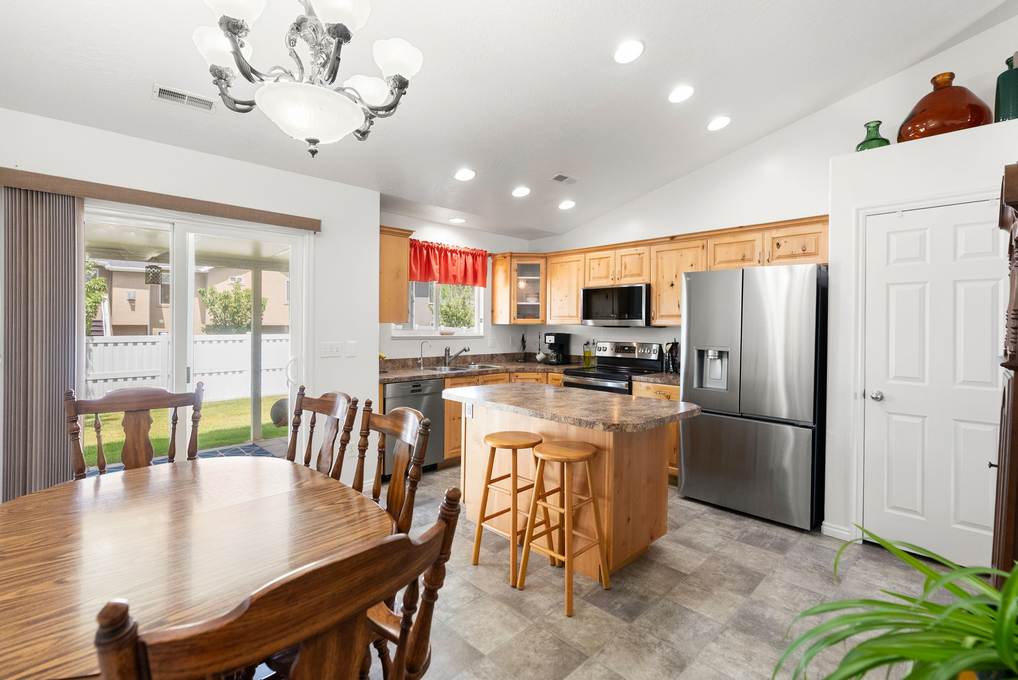 Eat-in kitchen featuring wood cabinetry, stainless steel appliances, and an island with countertop seating