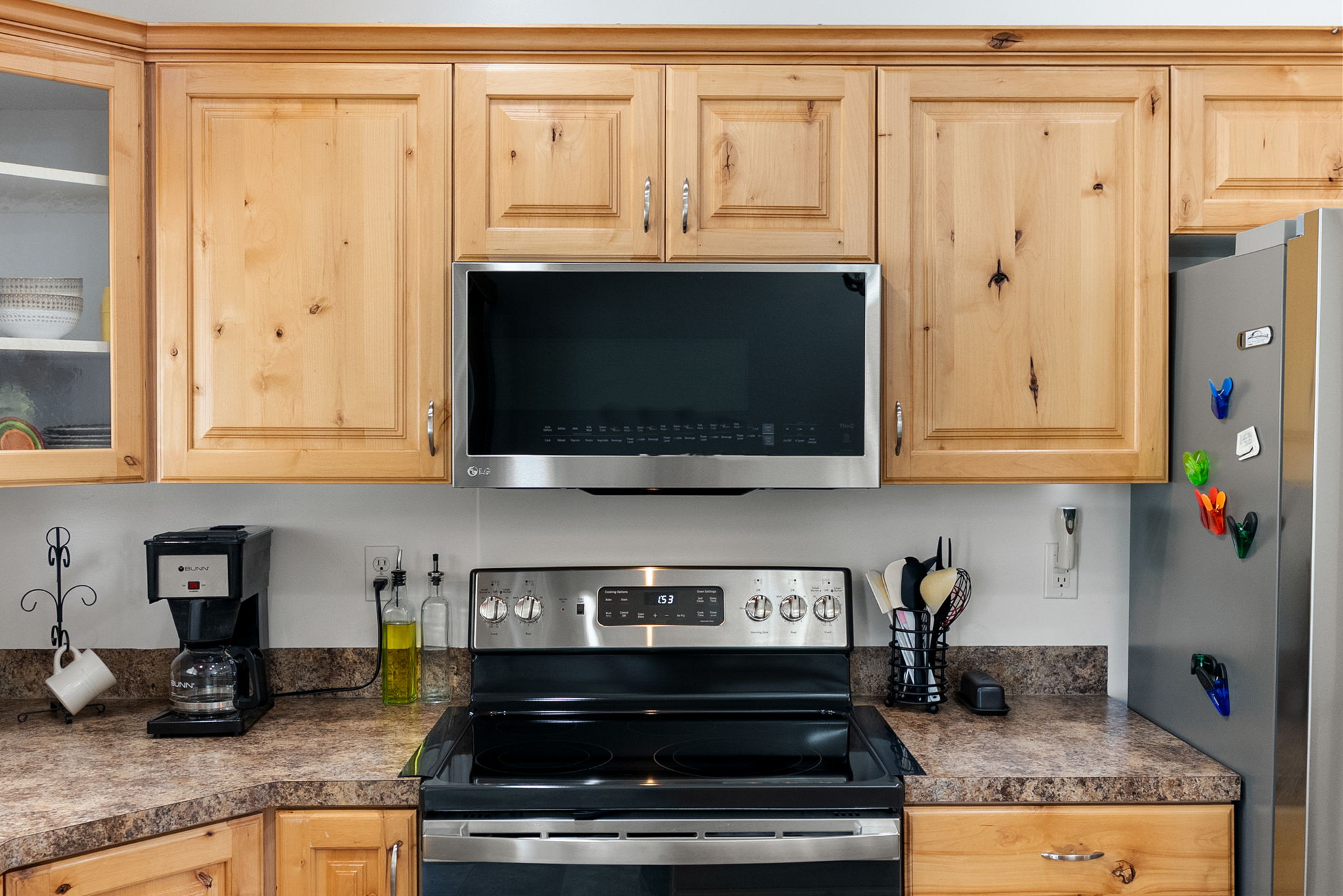Kitchen featuring natural wood cabinetry, stainless steel range, and built-in microwave