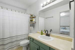 Bathroom vanity with a teal base cabinetry, a cream countertop, and a white oval sink featuring a matte black faucet