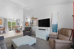 Vaulted ceiling living area with carpet flooring and light gray walls