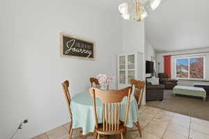 Tile flooring extending into a spacious area with vaulted ceilings