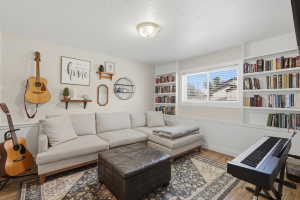 Finished room featuring wood-finish flooring, a neutral wall color, and built-in white shelving