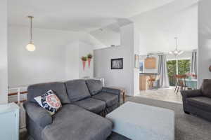 Open-concept living area with vaulted ceilings, large windows, and a dedicated dining space