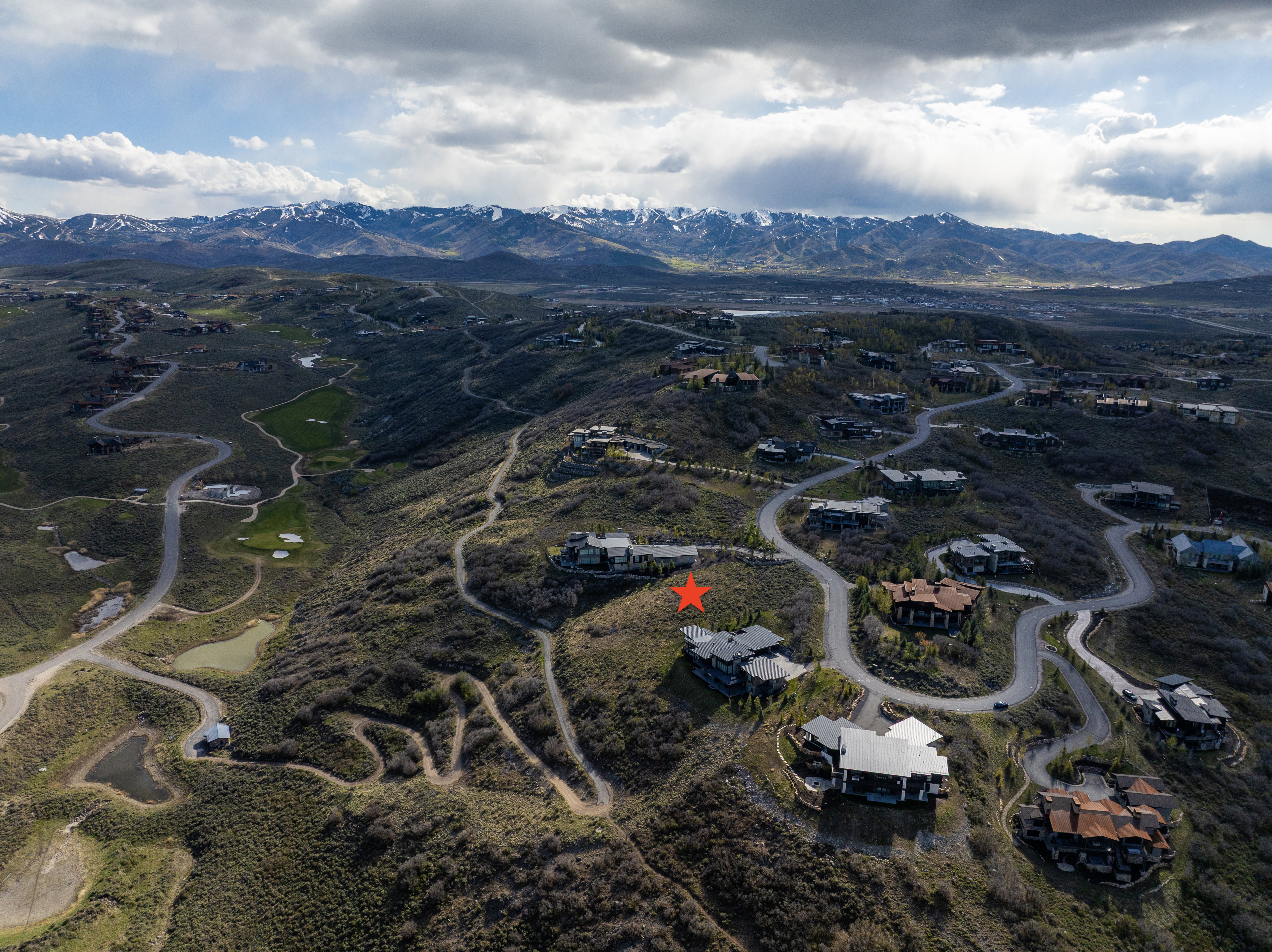 Expansive residential landscape featuring a mountainous backdrop with snow-capped peaks