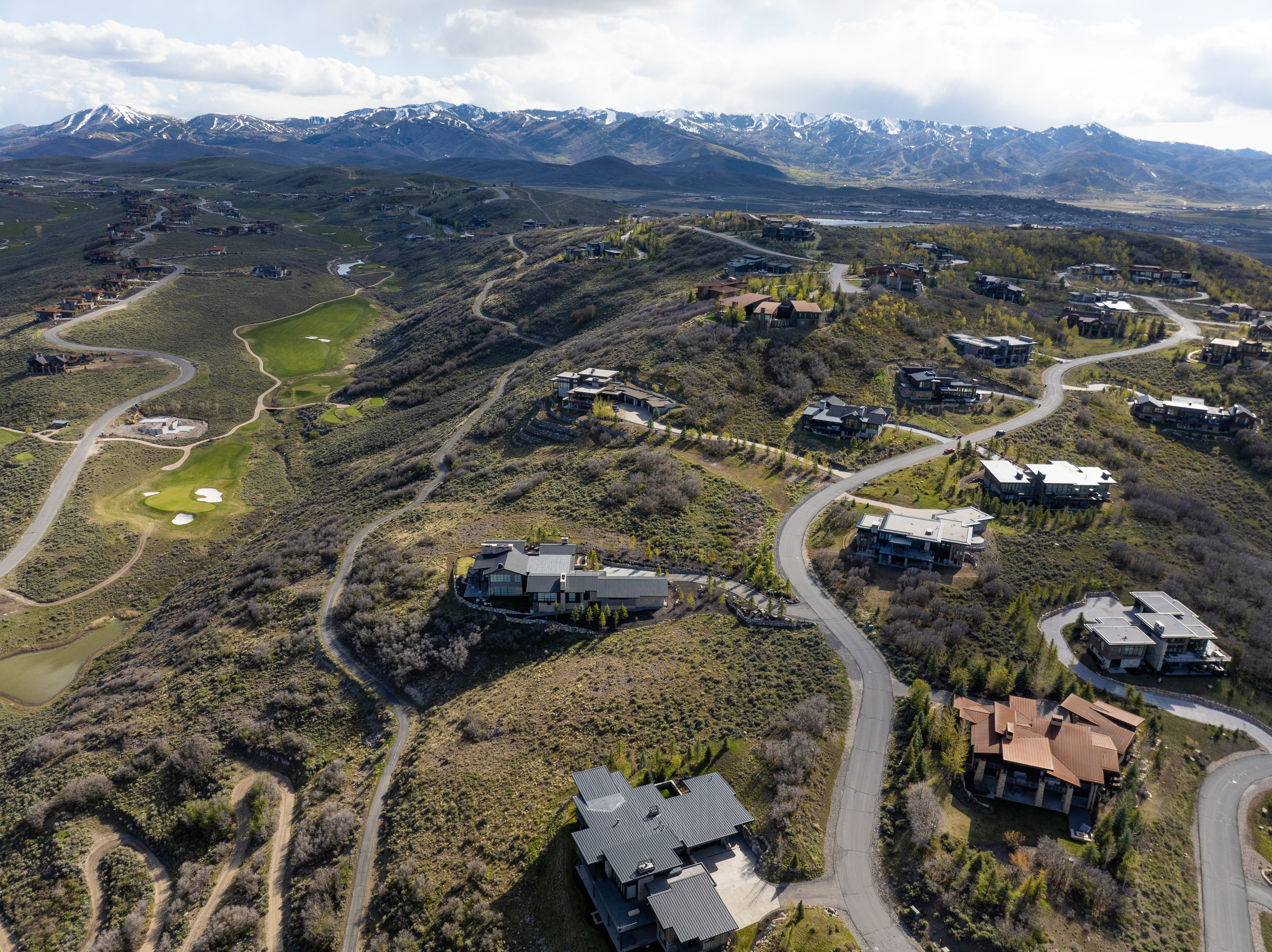 Mountainous terrain featuring modern residences and a golf course