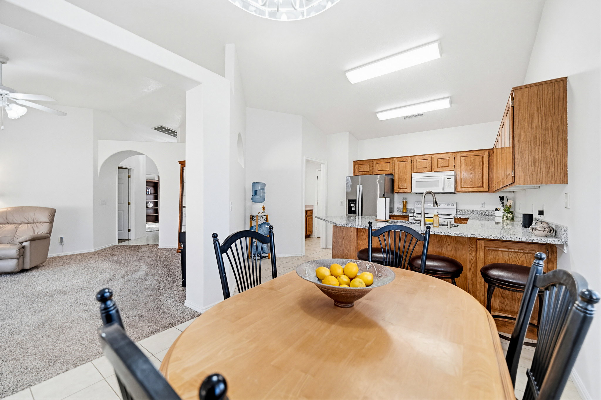 Kitchen featuring wood cabinetry, stainless steel appliances, and a breakfast bar with stone countertops