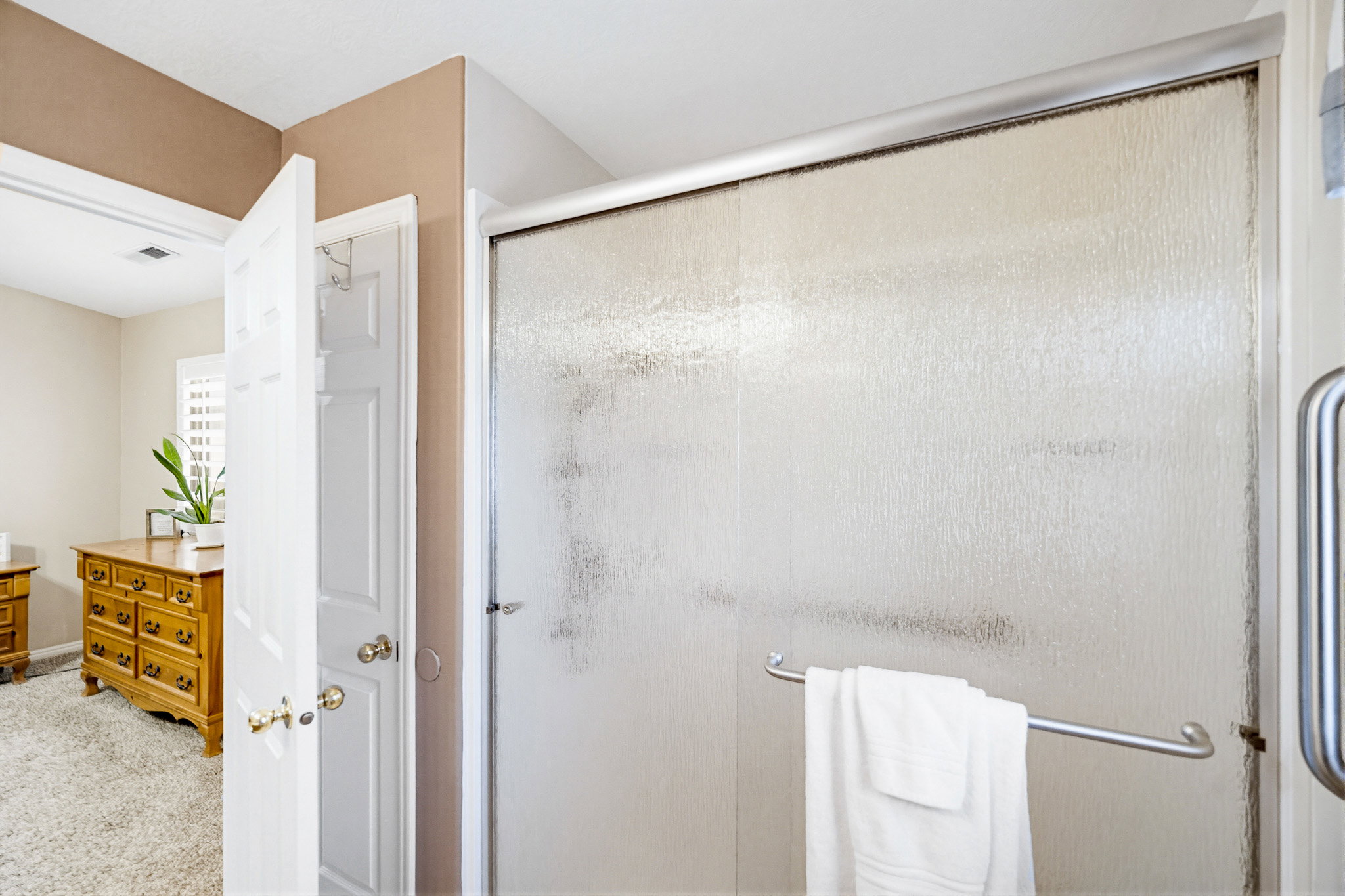 Shower enclosure featuring textured glass panels with an aluminum frame