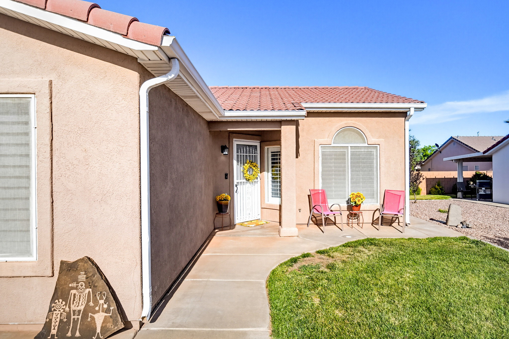 Stucco exterior with a tiled roof and an arched window above a front patio