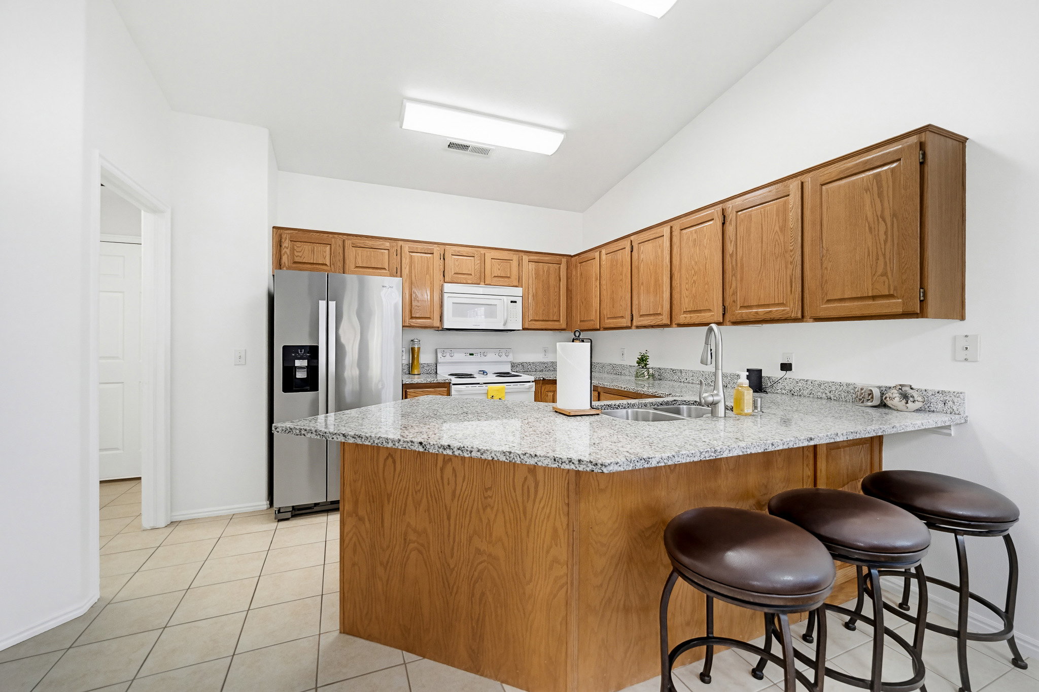 Kitchen featuring light wood cabinetry, granite countertops, and stainless steel appliances