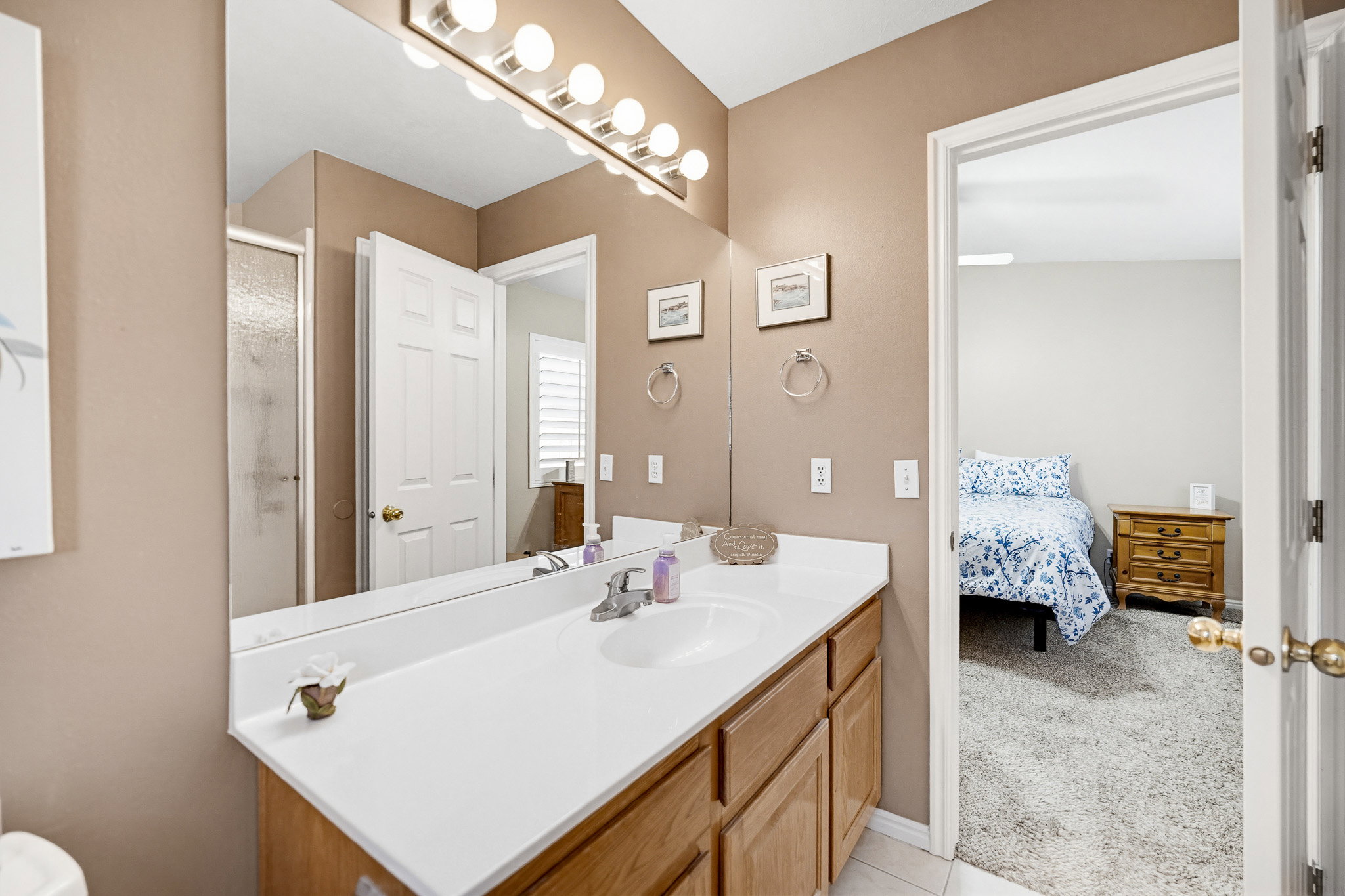 Bathroom vanity featuring an integrated sink, laminate countertop, and wood-finish cabinetry