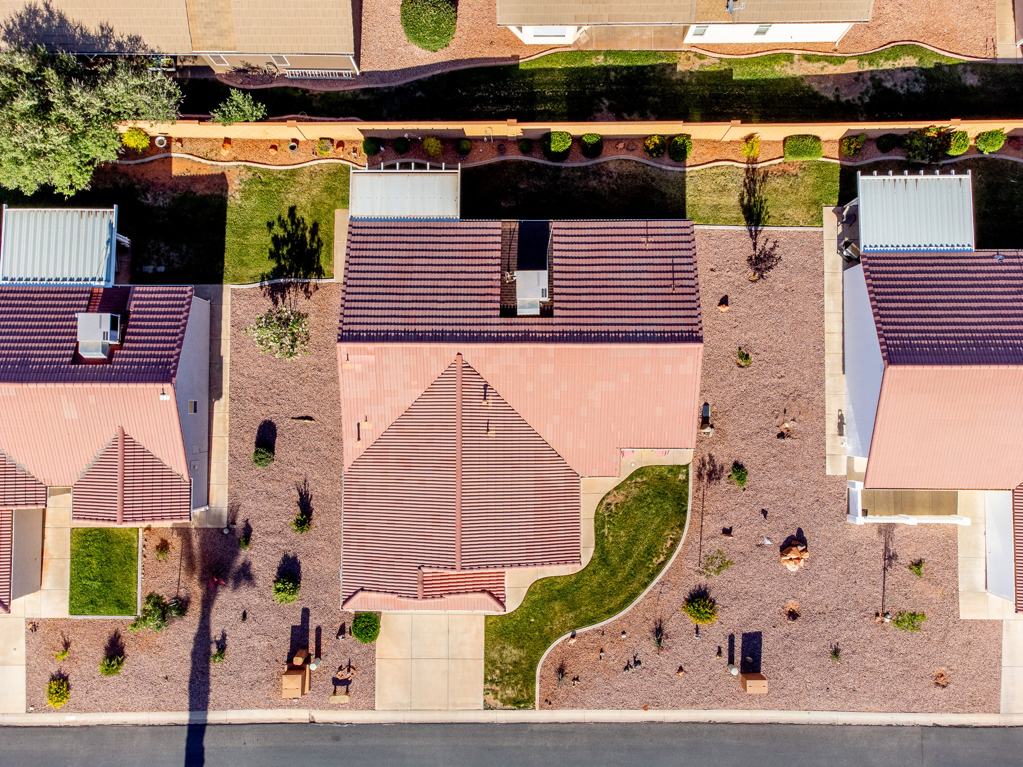 Aerial perspective showcasing the property's tile roof, a combination of xeriscaped and grass landscaping, and a concrete driveway