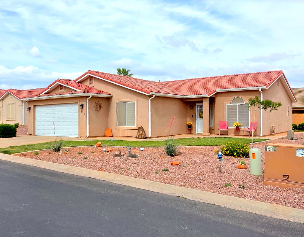 Southwestern-style residence featuring a terracotta tile roof, stucco exterior, and an attached two-car garage