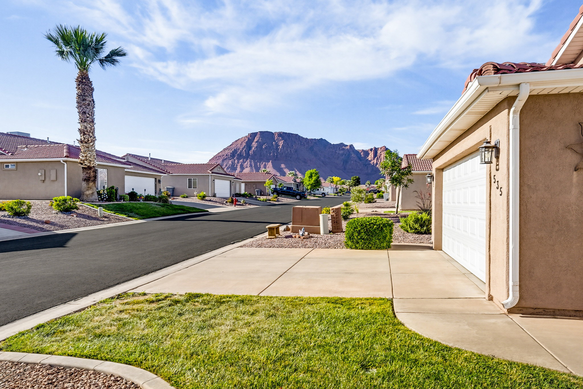 Property exterior featuring stucco siding, white paneled garage door, and a concrete driveway