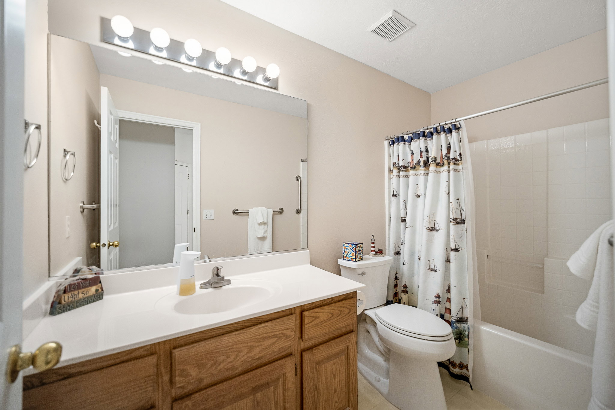 Bathroom featuring a light wood-finish vanity with a white countertop and integrated sink