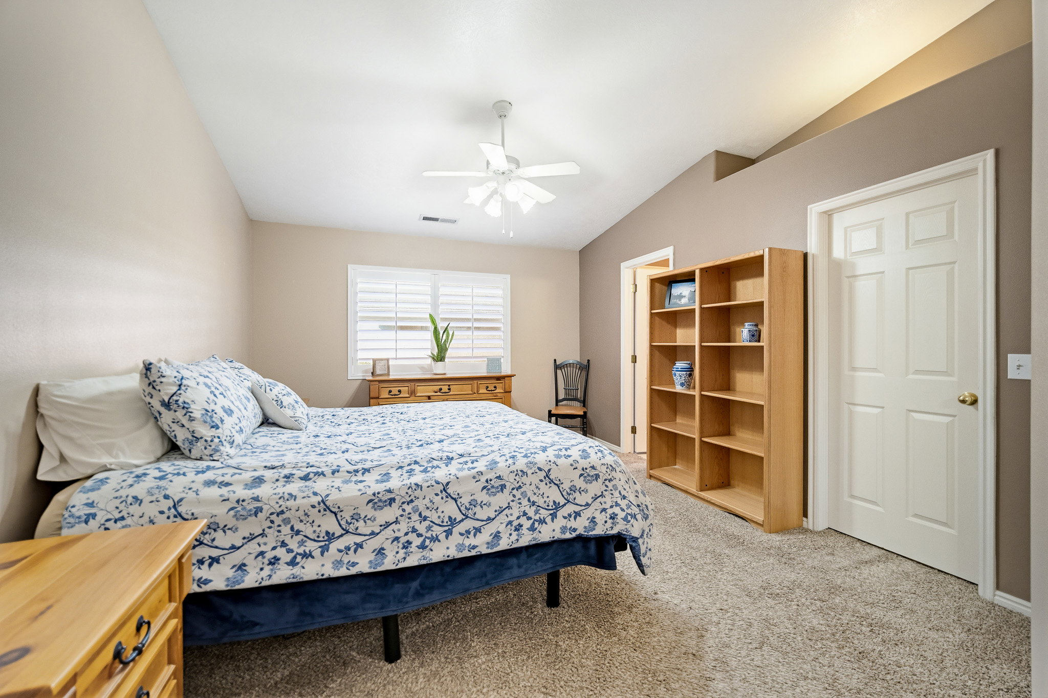 Carpeted room featuring a vaulted ceiling and ceiling fan