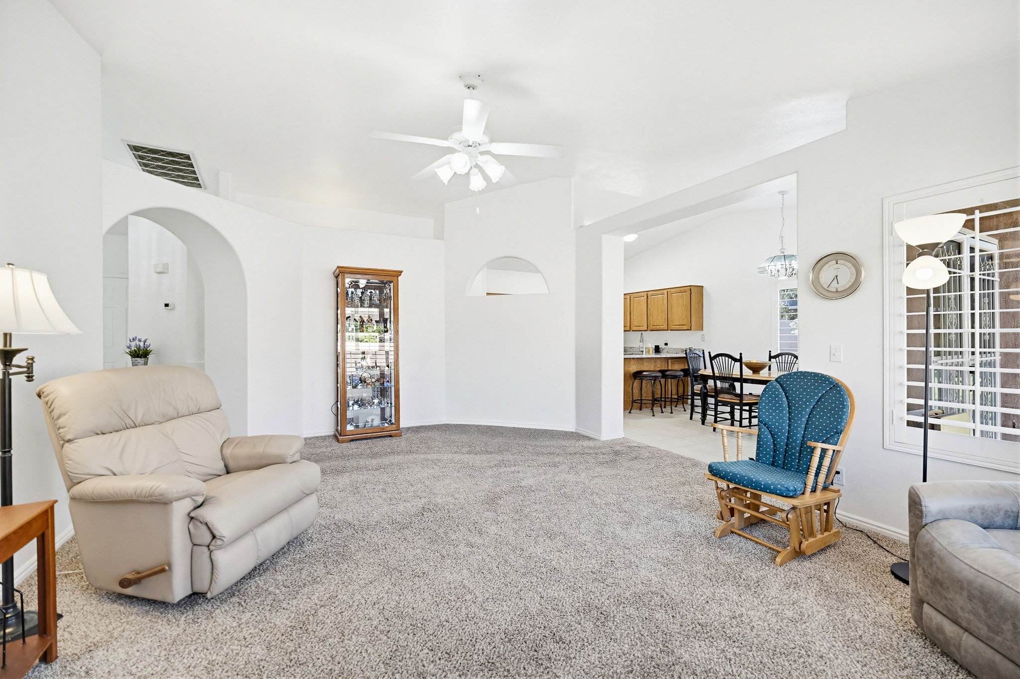 Spacious living area featuring neutral carpeting and vaulted ceilings