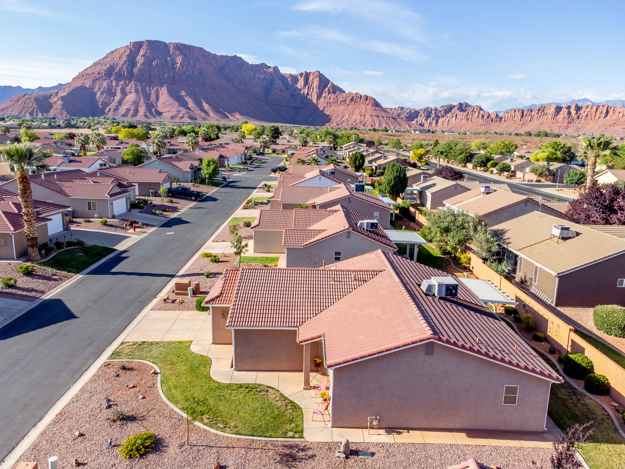 Community setting featuring red rock mountain backdrop, uniform architecture, and desert landscaping