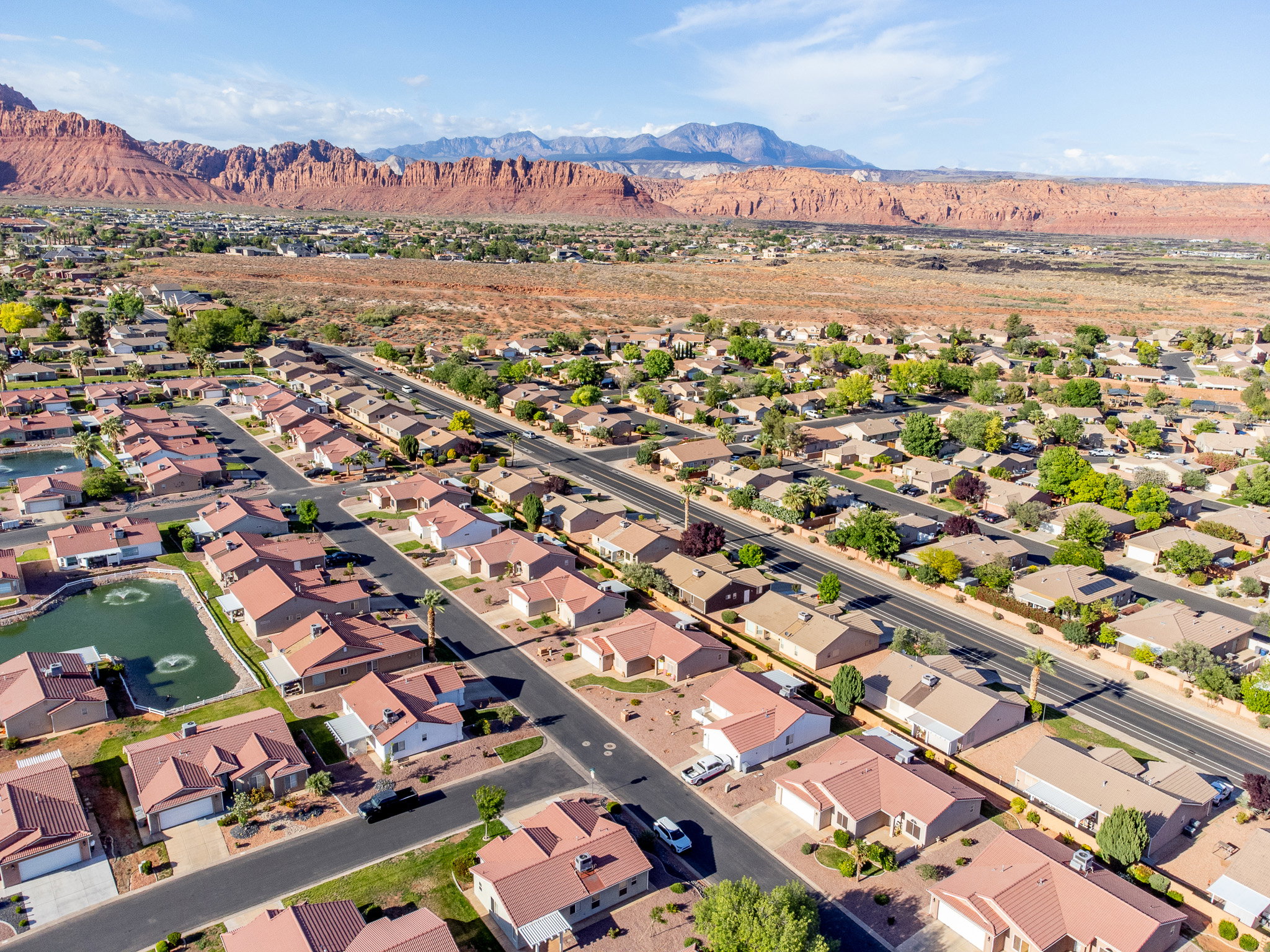 Expansive aerial perspective showcasing a residential community with red-tiled roof homes