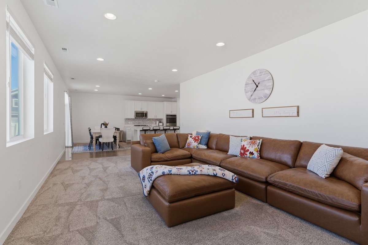 Open-concept living area featuring recessed lighting, a neutral carpet, and white walls