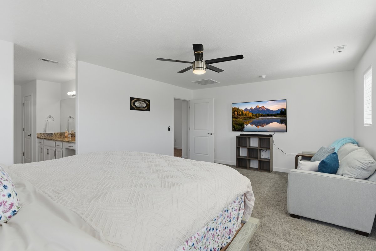 Carpeted room with a ceiling fan, a window with horizontal blinds, and a door