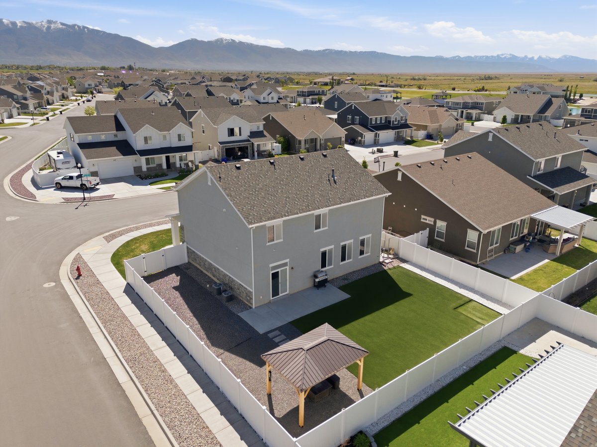 Rear exterior featuring a spacious fenced yard, gazebo, and patio area