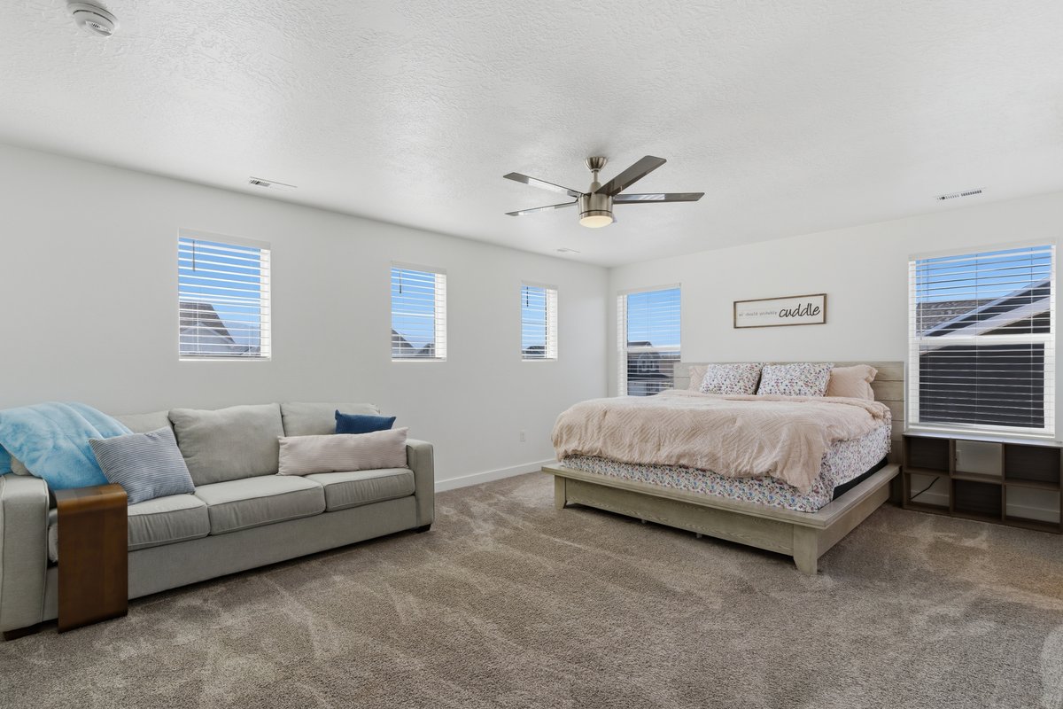 Spacious room featuring neutral carpeting and multiple windows with blinds