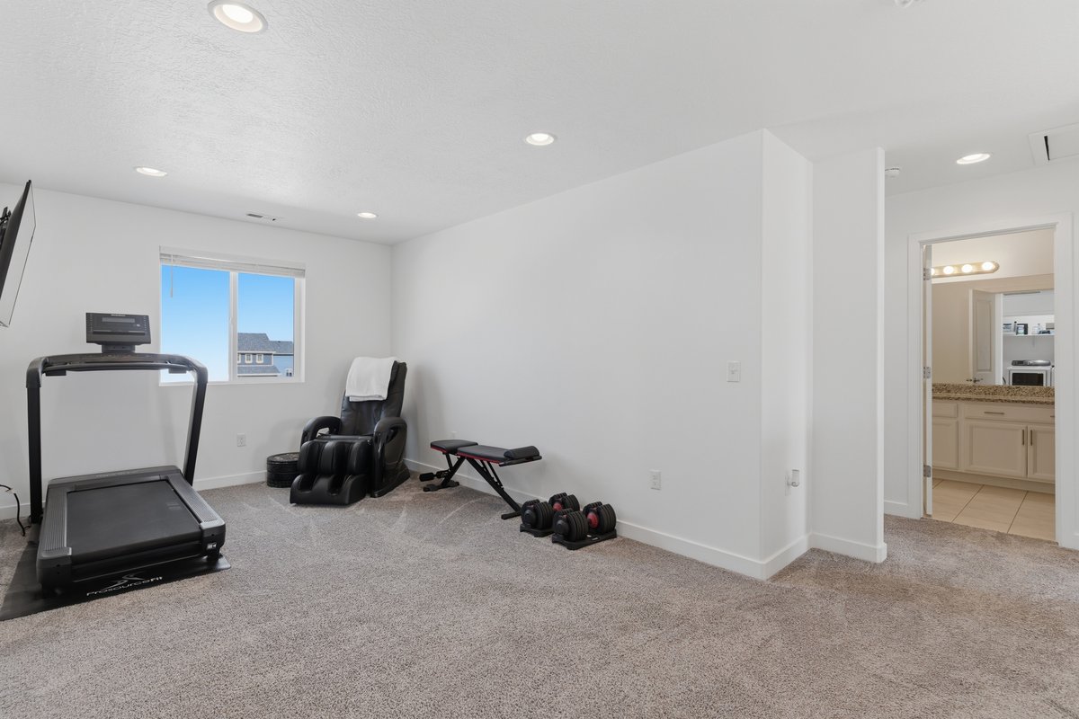 Spacious room with plush carpeting, recessed lighting, and a single window offering natural light