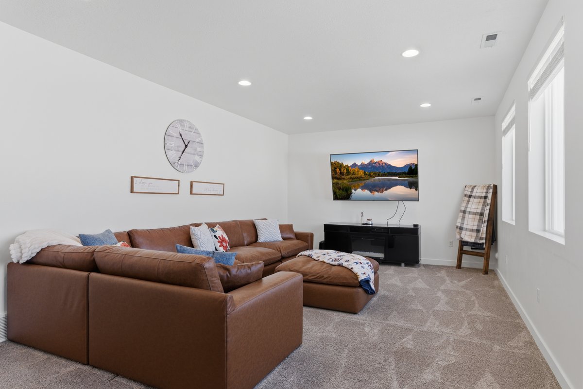 Spacious room featuring neutral carpeting, recessed lighting, and multiple windows providing natural illumination