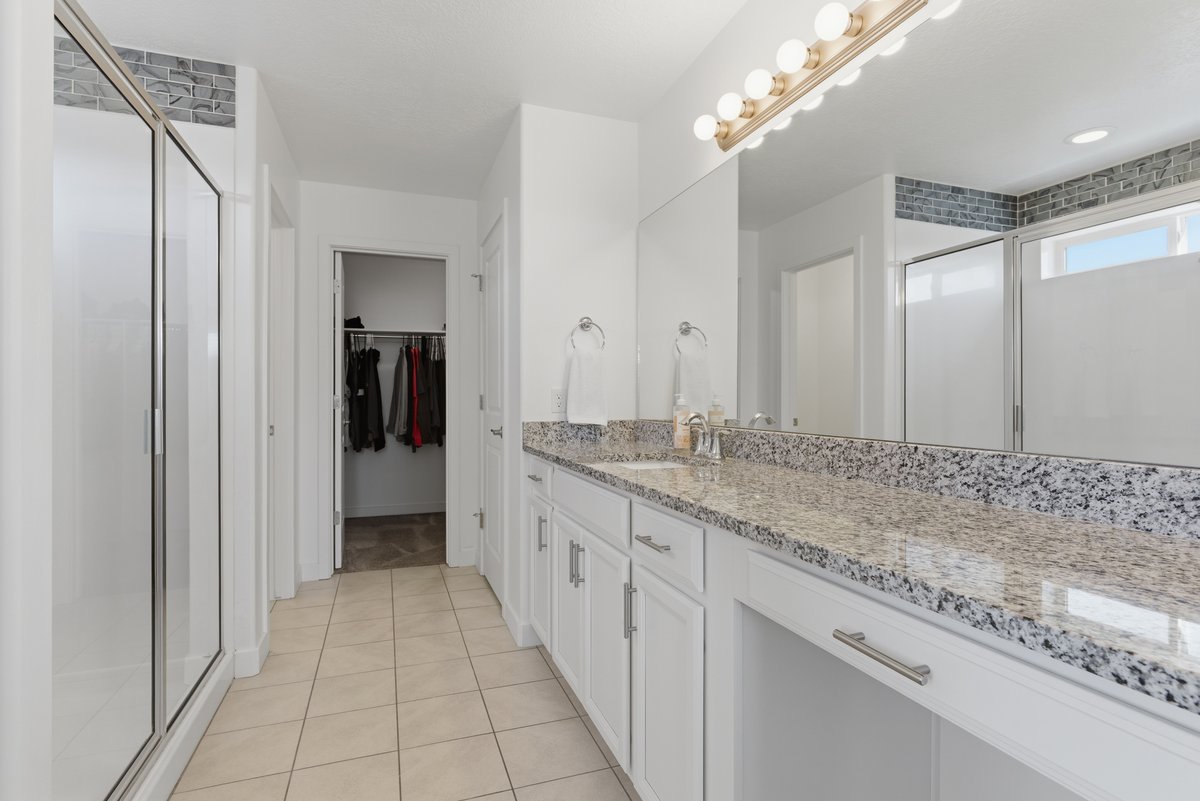 Dual vanity with granite countertop and white cabinetry