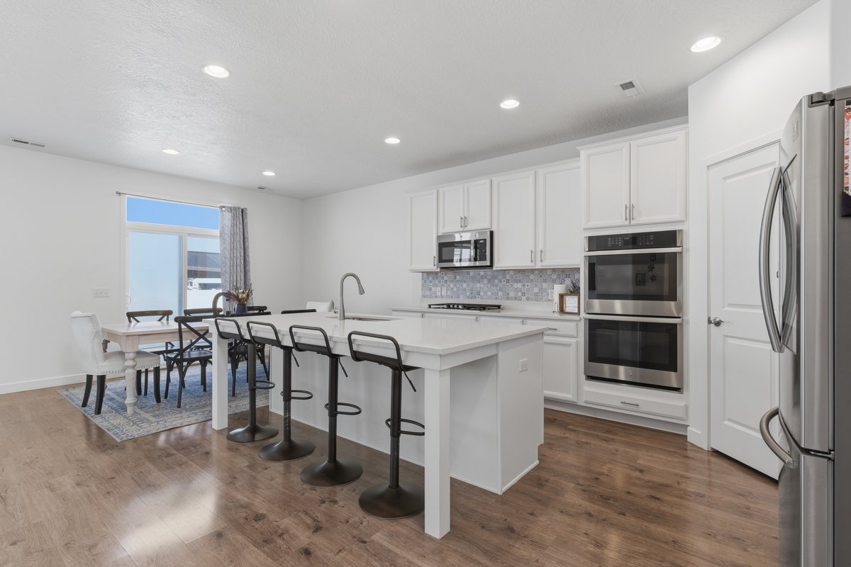 Modern kitchen featuring wood-finish flooring and a central island with countertop seating