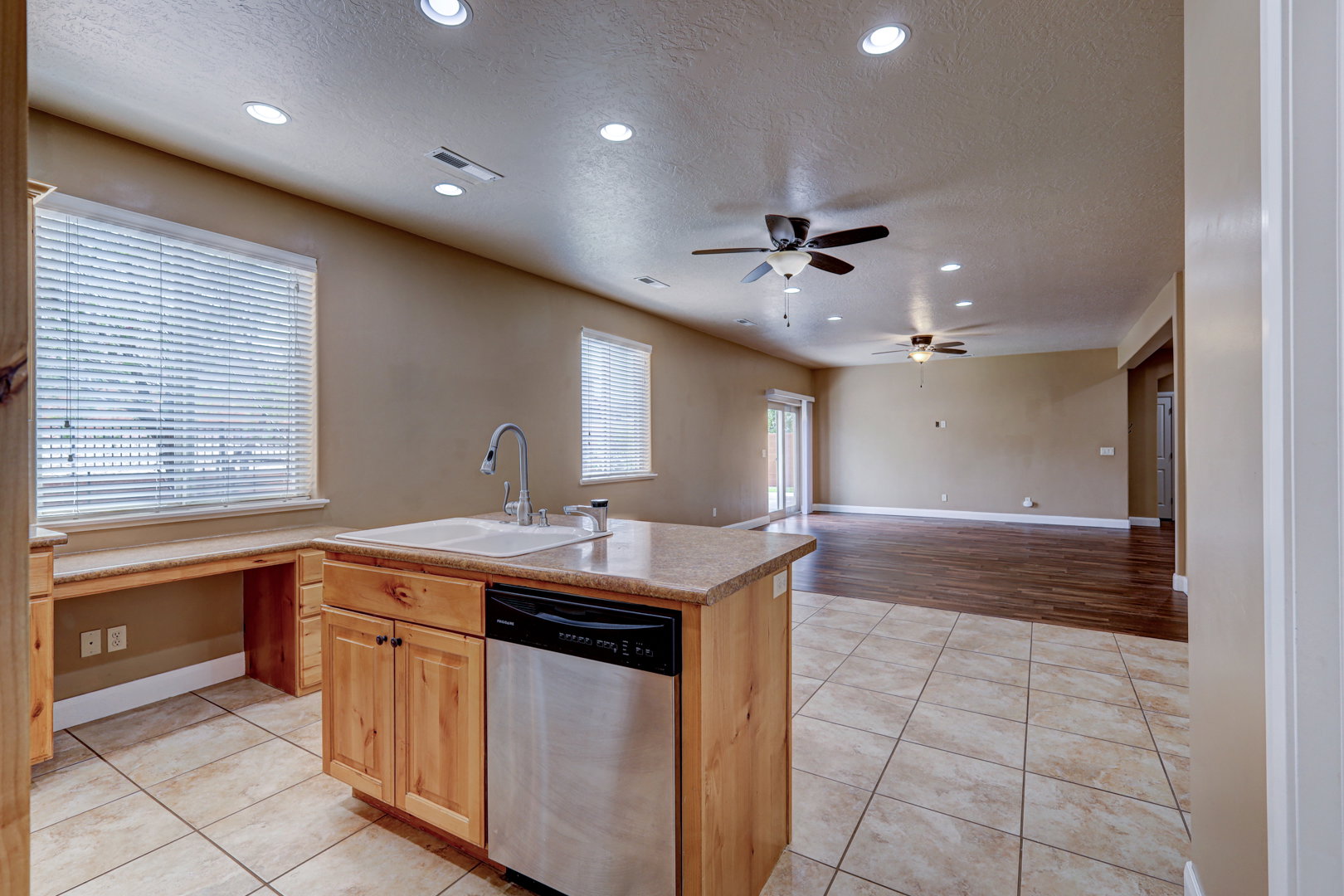 Kitchen island featuring a built-in sink and stainless steel dishwasher