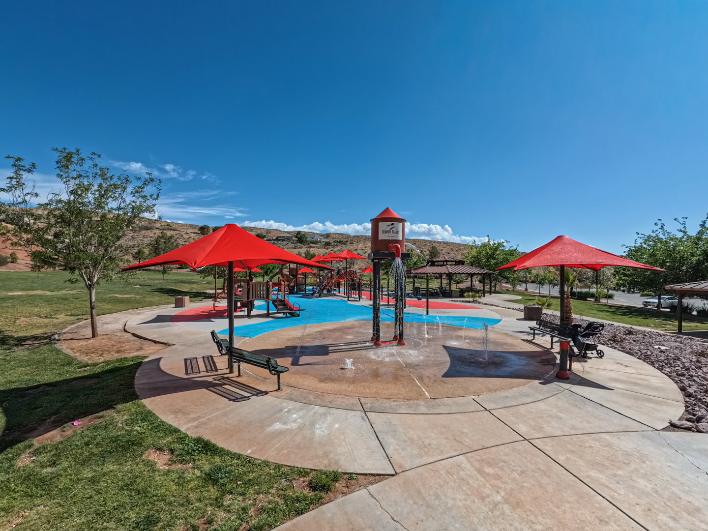 Expansive splash pad area featuring vibrant blue and red surfacing