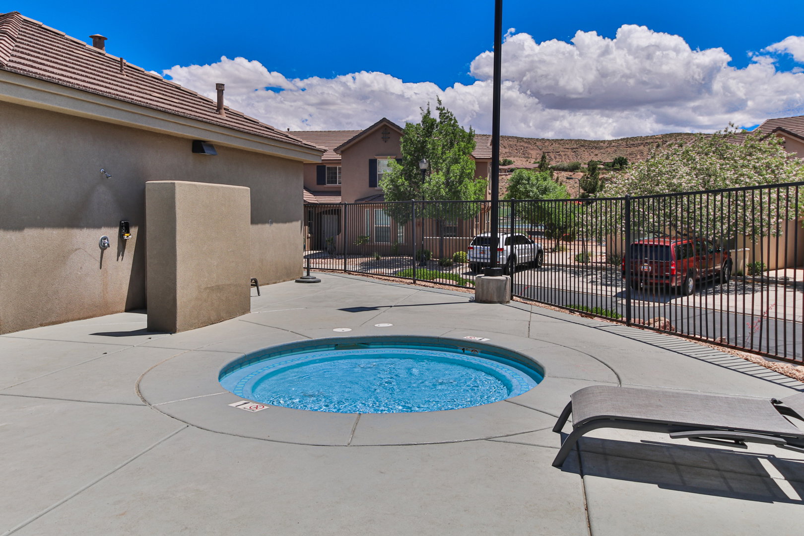Built-in spa with surrounding concrete patio and perimeter fencing