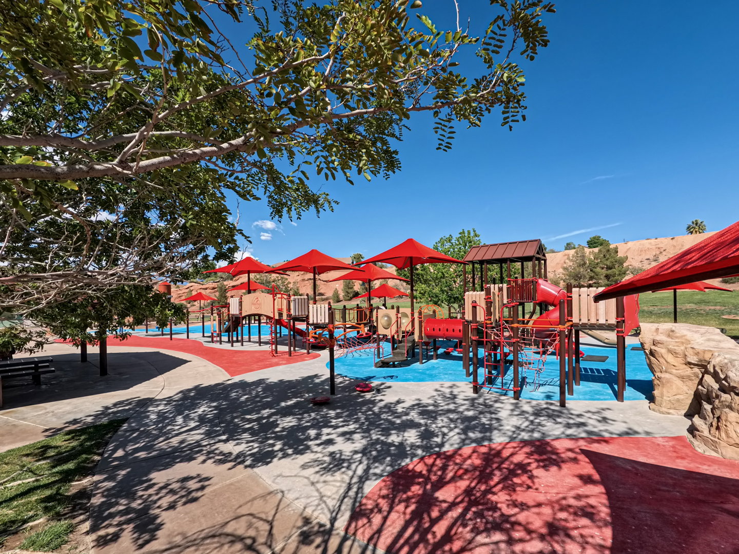 Recreational park area featuring a multi-level playground structure with slides and climbing elements