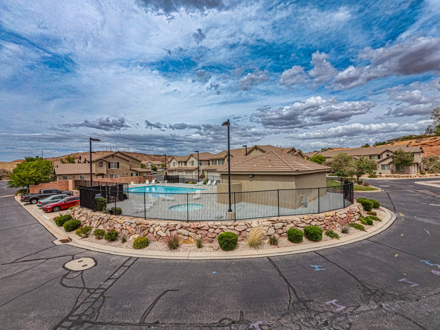 Community swimming pool featuring a perimeter fence and integrated hot tub