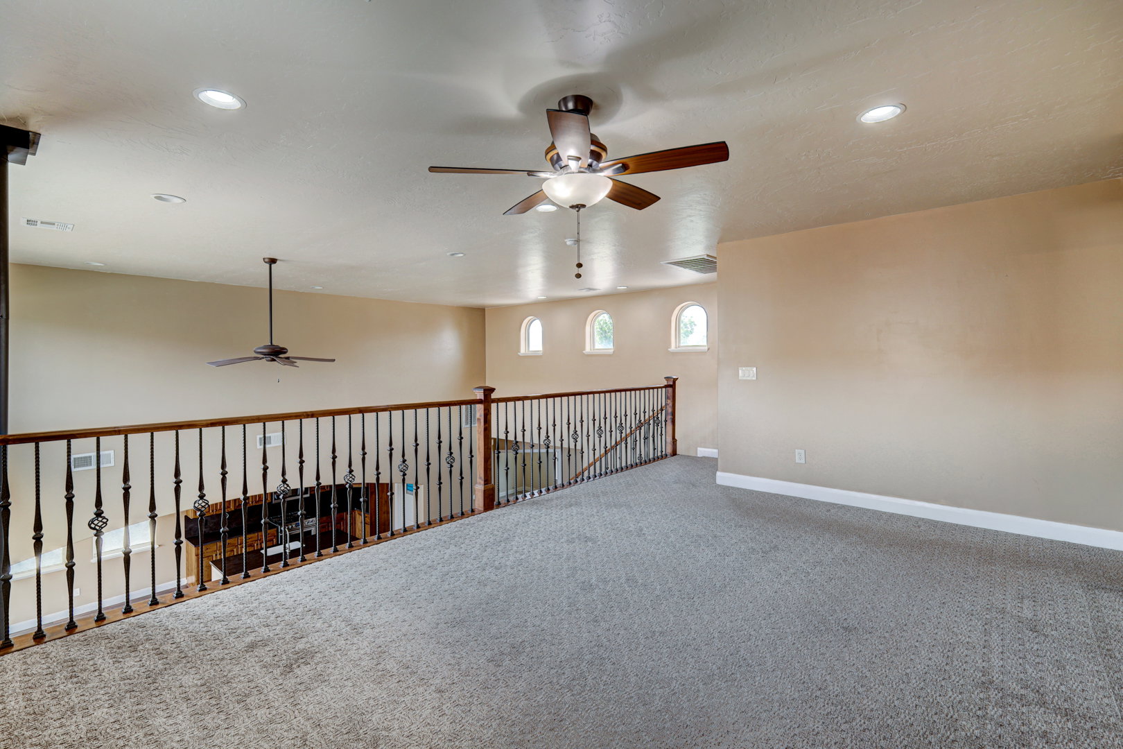 Expansive loft area featuring neutral-toned carpeting and recessed lighting