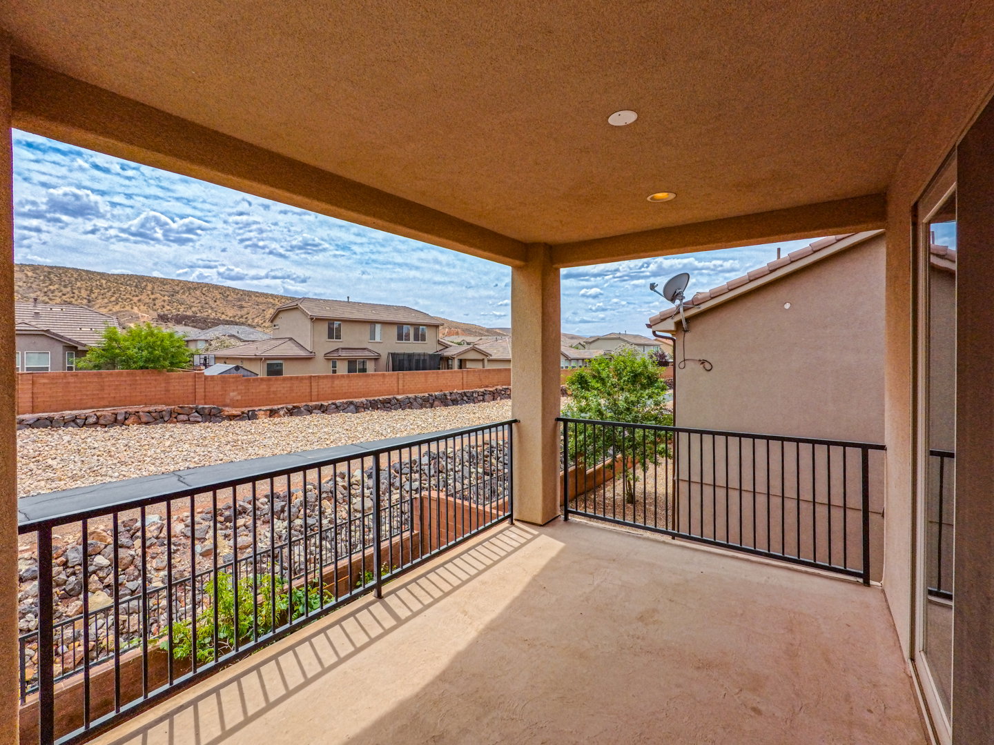 Expansive outdoor balcony featuring a neutral-toned ceiling, recessed lighting, and durable concrete flooring