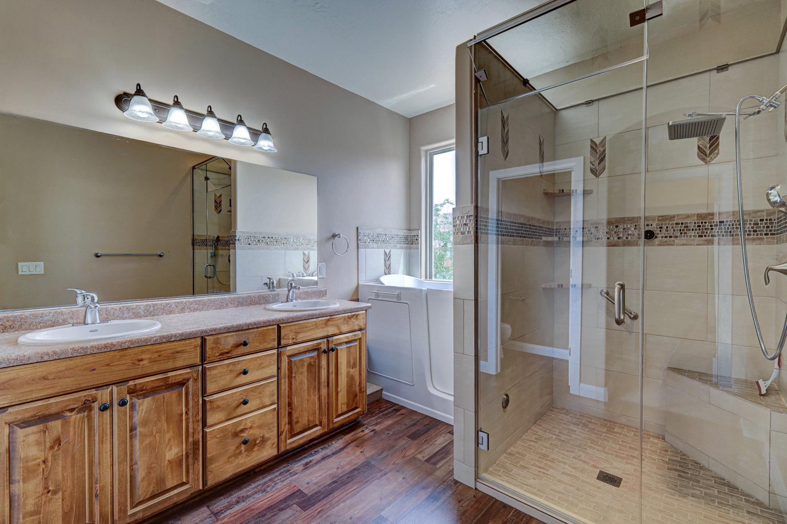 Wood-finish flooring complementing a dual vanity with light-toned countertops