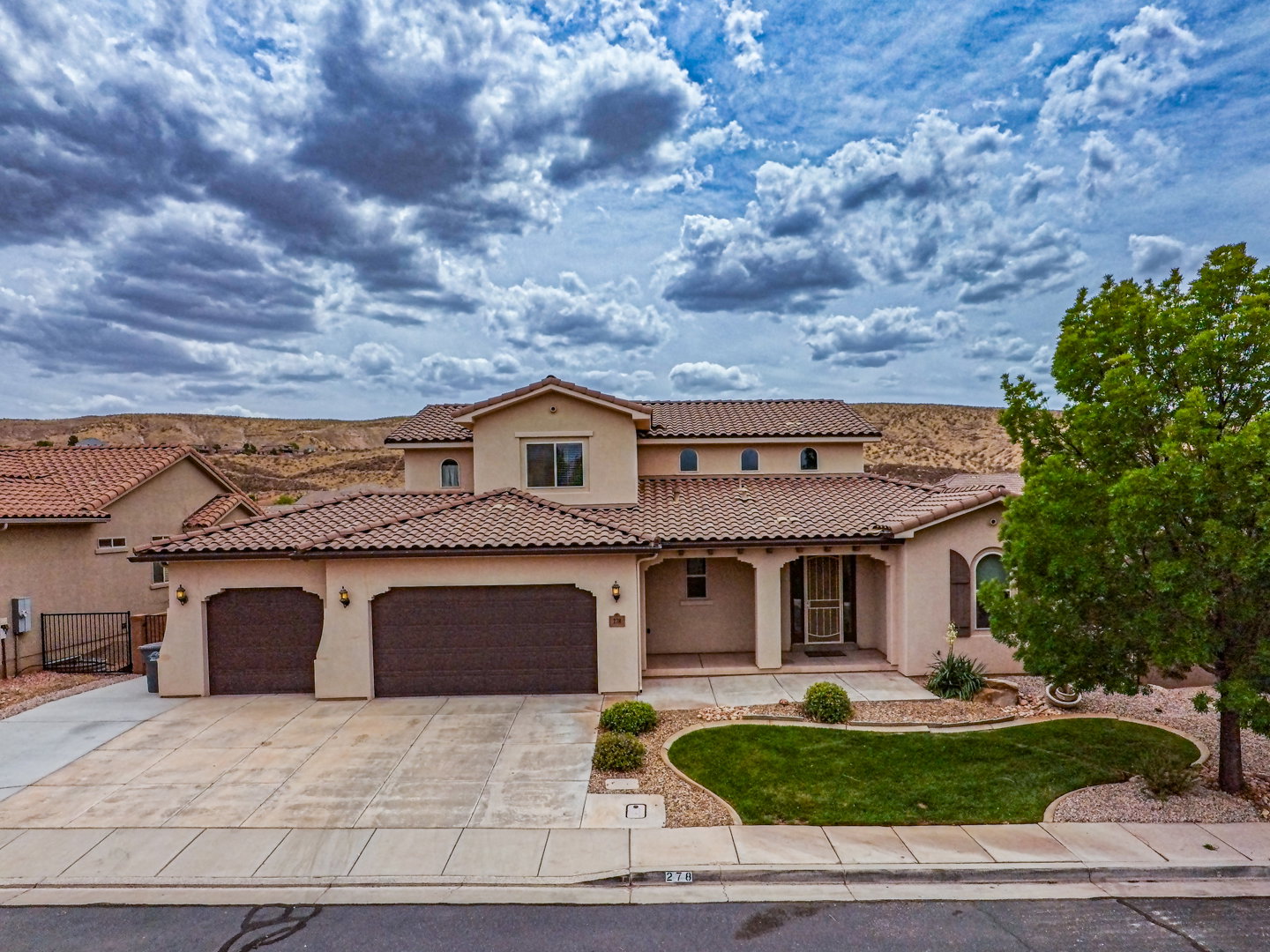 Stucco exterior residence with a tile roof and integrated two-car garage