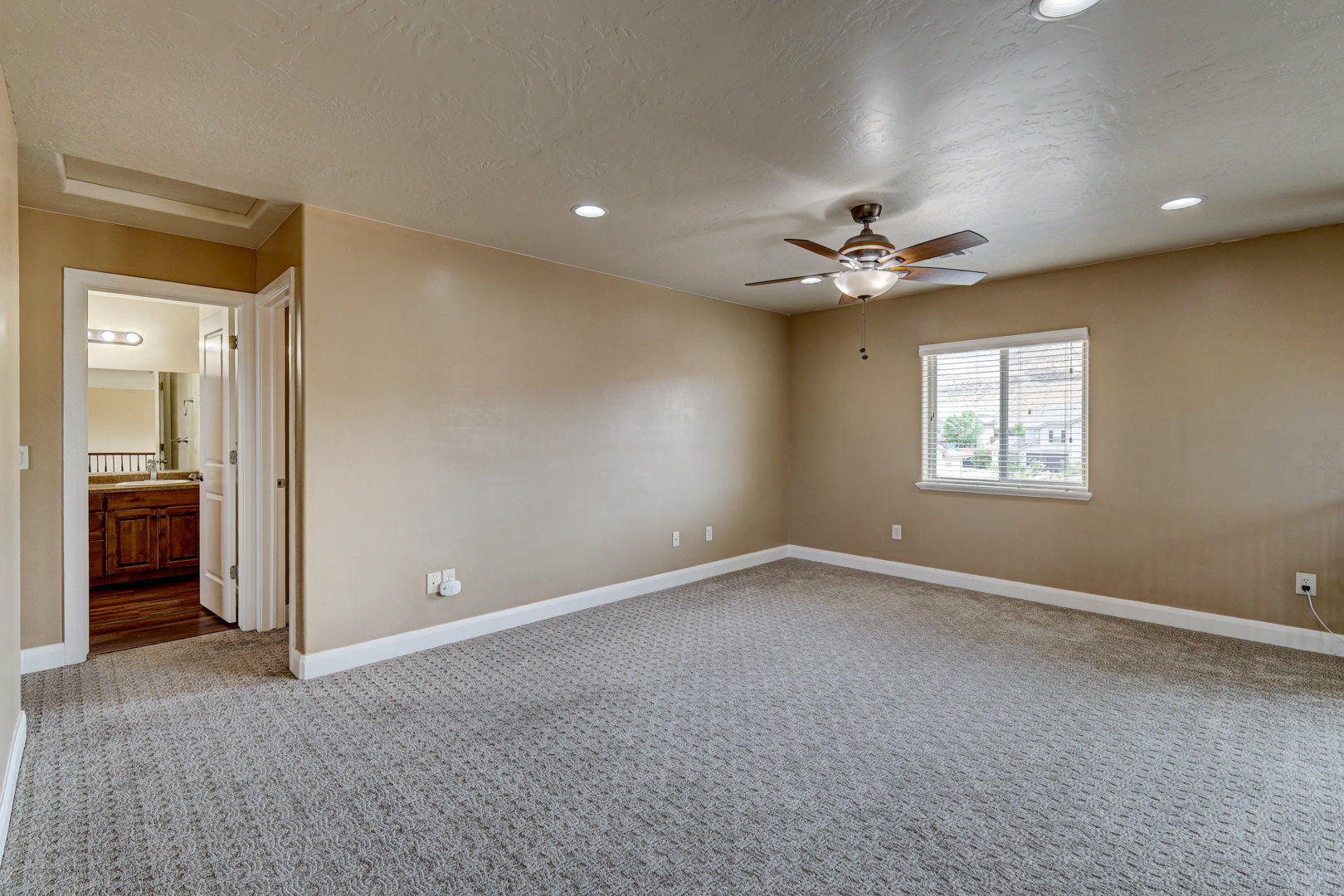 Carpeted room featuring a ceiling fan, recessed lighting, and a window with blinds