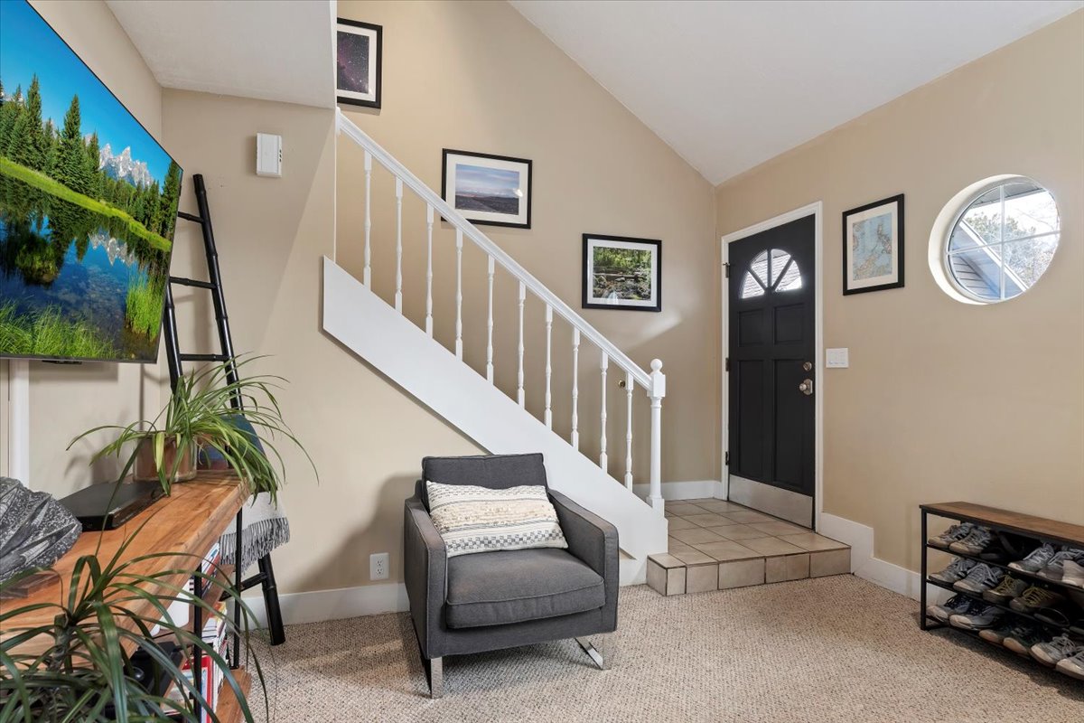 Light beige wall paint, a carpeted floor, and white trim characterize this entry area
