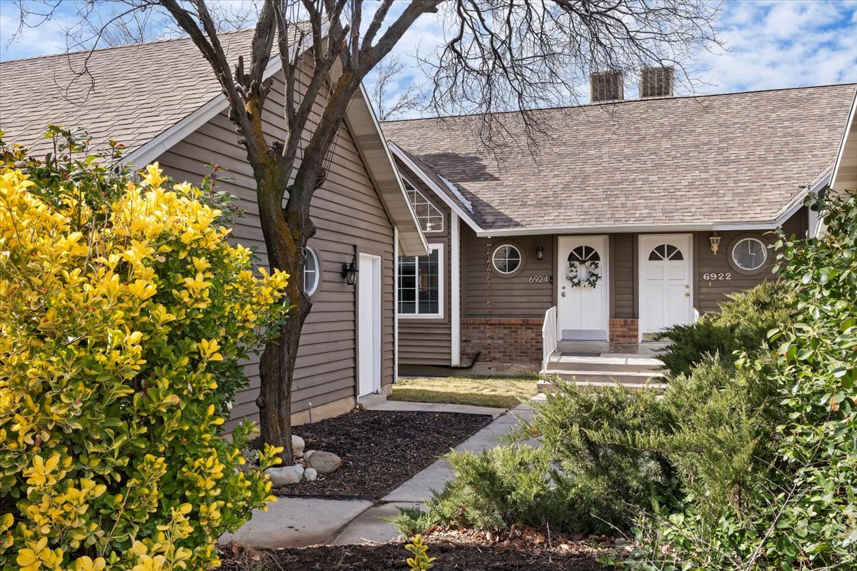 Brown siding exterior with a shingled roof and brick detailing