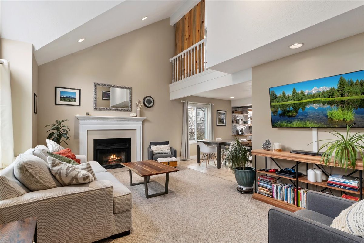 Living area featuring vaulted ceilings, a built-in fireplace with a white mantel, recessed lighting, and carpet flooring