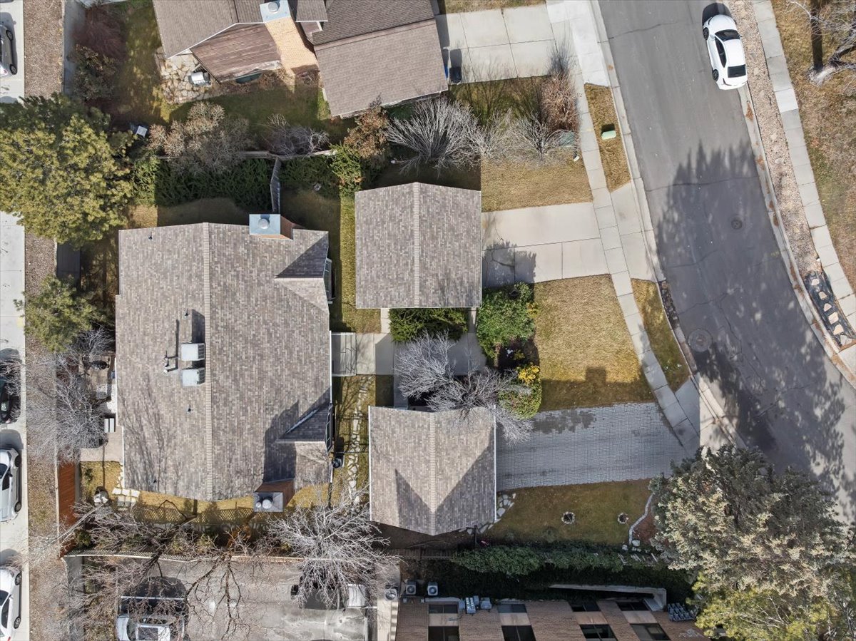 Aerial perspective showcasing two distinct structures with composite shingle roofing and multiple roof-mounted mechanical units