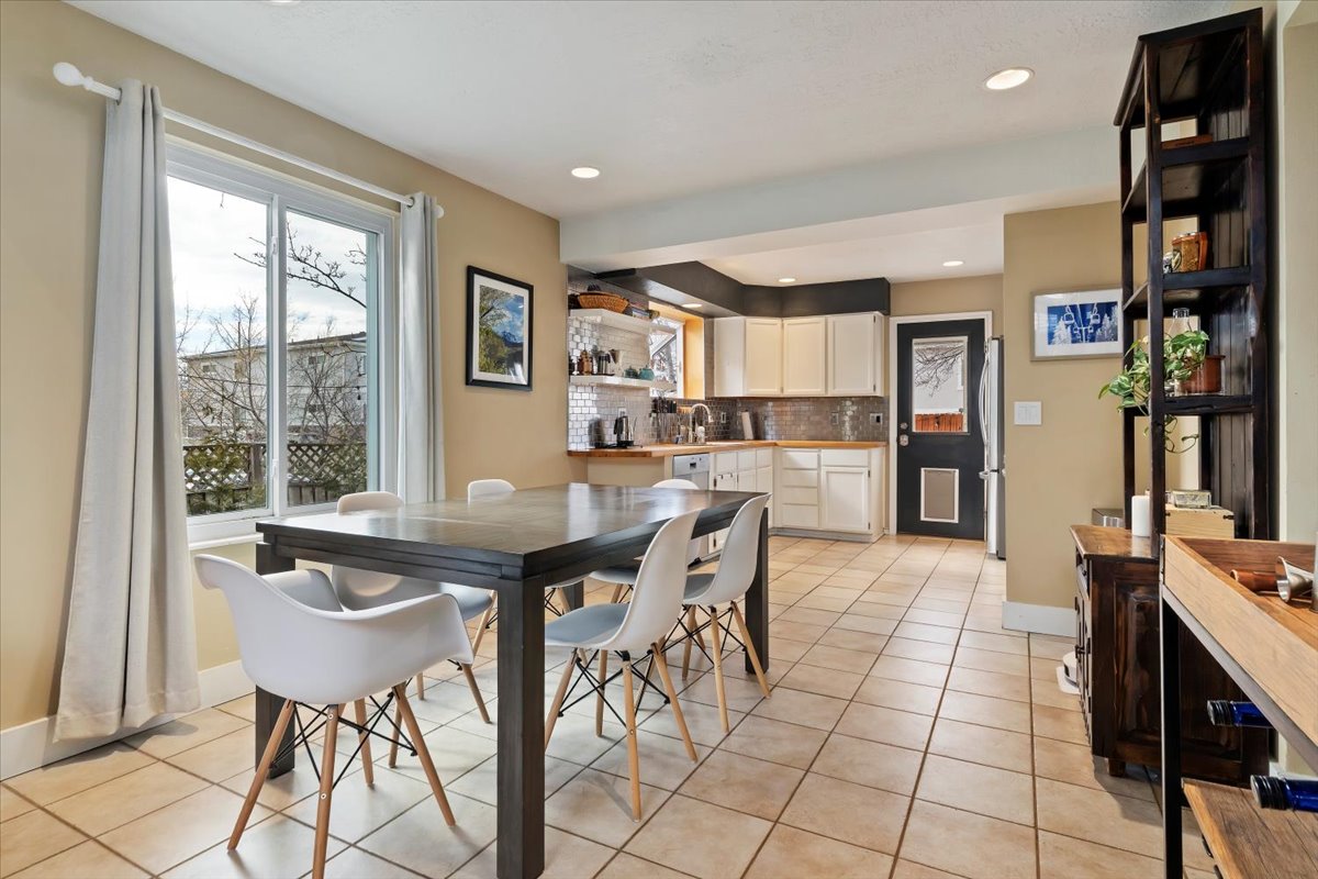Open concept living space featuring a dining area with a large window and tile flooring