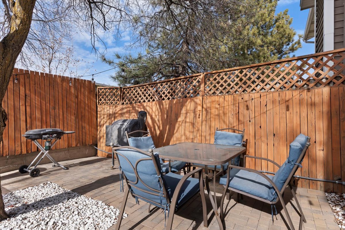 Brick paver patio featuring a wood privacy fence with lattice accents