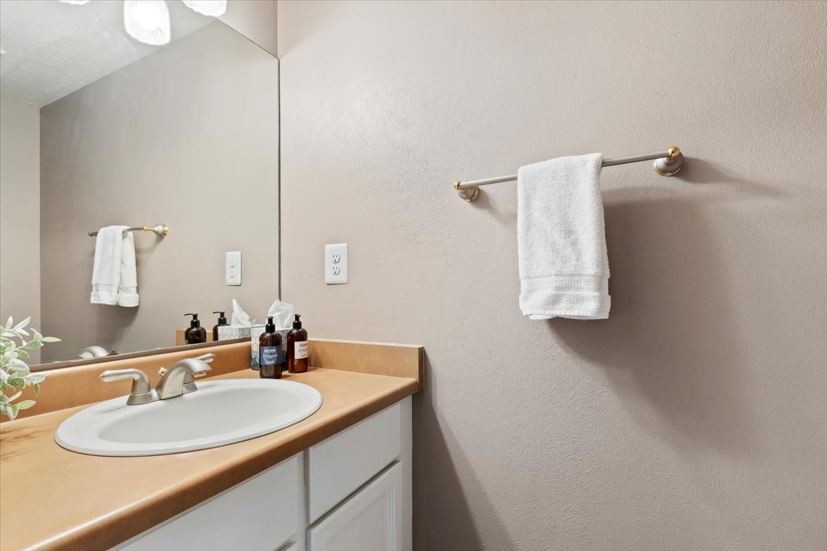 Bathroom vanity featuring a light brown countertop with an integrated oval sink