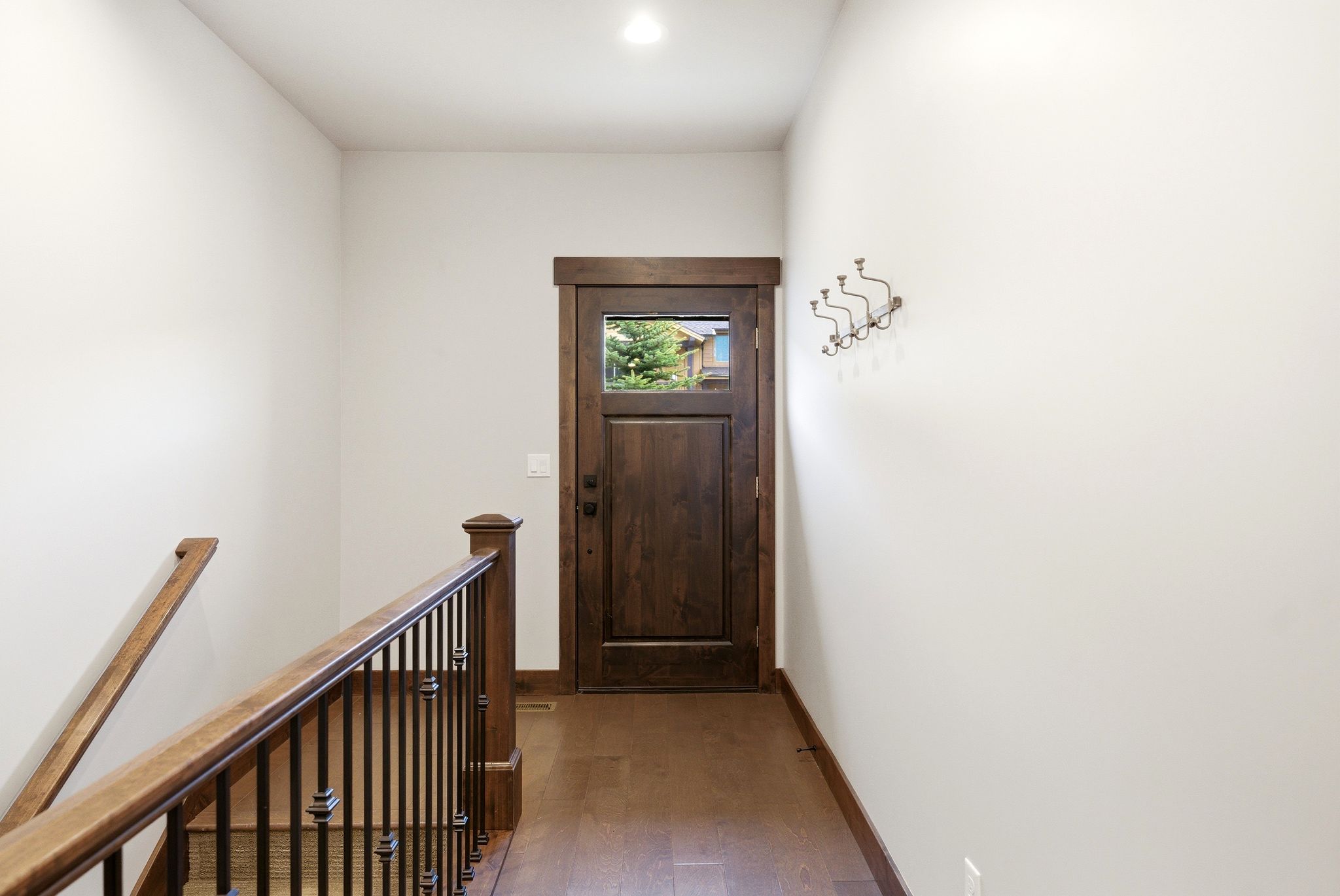 Rich wood-finish entry door with a clear glass insert
