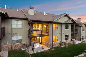 Multi-level property exterior with light green siding and stone veneer accents