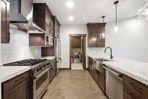 Galley-style kitchen featuring dark wood cabinetry, light-colored countertops, and stainless steel appliances